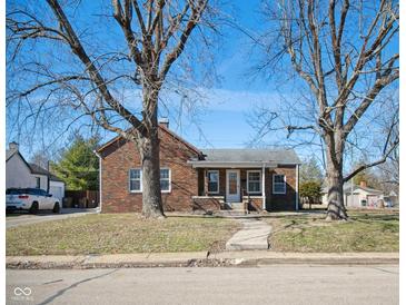 Charming brick home with a covered front porch, mature trees, and a well-maintained lawn at 2022 Newton St, Columbus, IN 47201