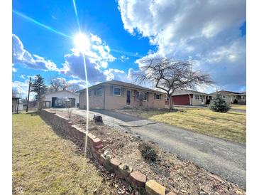 Charming single-story brick home featuring a well-manicured front yard and a private driveway on a sunny day at 505 Birch St, Beech Grove, IN 46107