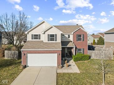 Charming two-story home with brick accents, a well-maintained lawn, and attached two car garage at 8352 Alcona Dr, Indianapolis, IN 46237
