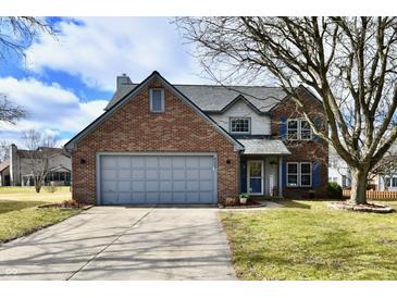 Charming two-story brick home with attached garage, well-kept lawn and mature trees at 8503 Hoff Ct, Indianapolis, IN 46256