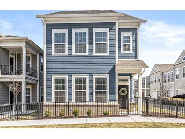 Charming blue two-story home featuring a welcoming front door with a decorative wreath and a neat, fenced yard at 1004 Astor Ln, Carmel, IN 46032