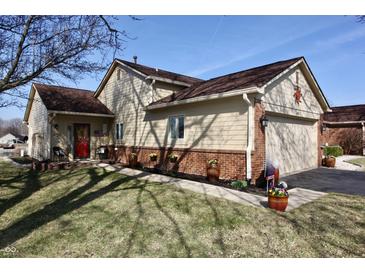 Charming single-story home with a landscaped front yard, red door and attached two car garage at 1939 Crystal Bay E Dr, Plainfield, IN 46168