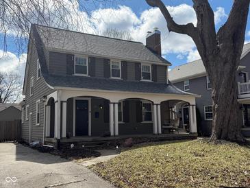 Charming two-story home with a welcoming front porch, dark shutters and a beautifully maintained lawn at 207 Blue Ridge Rd, Indianapolis, IN 46208