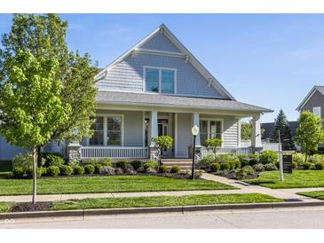 Inviting home with a covered porch, well-manicured lawn, and mature landscaping at 2274 Finchley Rd, Carmel, IN 46032