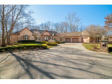 Beautiful brick home featuring an attached three-car garage, inviting curb appeal, and a circular driveway at 2688 S Oscar Ct, Morgantown, IN 46160