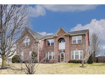 Charming two-story brick home with a well-manicured lawn and beautiful architectural details at 3229 Autumn Ash Dr, Zionsville, IN 46077