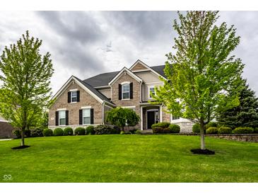 Beautiful two-story brick home with a well-manicured lawn and mature trees at 3905 Pelham Rd, Carmel, IN 46074