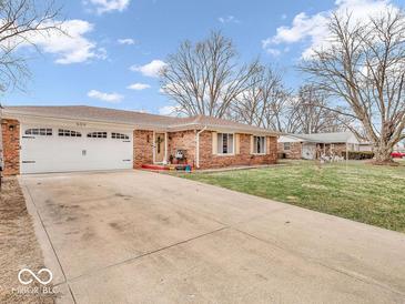 Charming brick ranch home features a two car garage, mature trees, and well maintained lawn at 504 Pelenor Dr, Franklin, IN 46131
