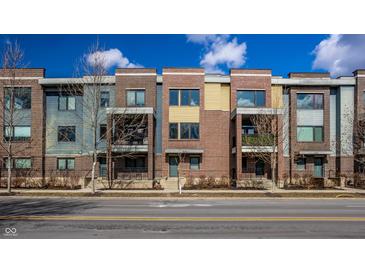 Attractive townhomes feature brick and siding exteriors, with small balconies under a partly cloudy sky at 606 E 10Th St, Indianapolis, IN 46202