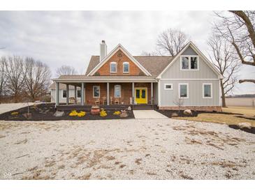 Charming two-story home featuring a cozy front porch and bright, eye-catching yellow front door at 695 N 650 W, Lebanon, IN 46052