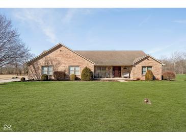 Charming brick home with a well-manicured lawn, mature trees, and a welcoming front porch at 7260 N 225 W, Lebanon, IN 46052