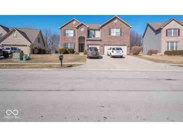 Two-story brick home featuring an attached two-car garage and a well-maintained front yard at 7536 Shasta Dr, Indianapolis, IN 46217