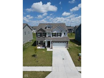 Charming two-story home featuring a two-car garage, dormer windows, and well-manicured landscaping at 10202 Meadow Path Ln, Indianapolis, IN 46239