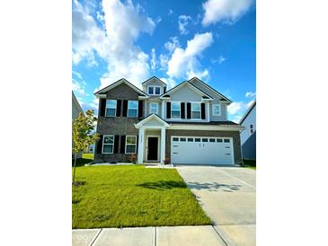 Charming two-story home with a well-manicured lawn, gray brick and gray siding, a 2-car garage, and black shutters at 10202 Meadow Path Ln, Indianapolis, IN 46239