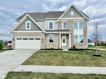 Charming two-story home featuring a gray brick facade, attached two-car garage and a well-manicured lawn at 1101 Knoll Ct, Greenwood, IN 46143