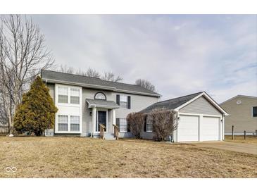 Charming two-story home with gray siding, a well-manicured lawn, and an attached two-car garage at 11410 Dunshire Dr, Indianapolis, IN 46229