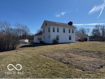 Sprawling white two-story home with a chimney and well-maintained lawn, set against a clear blue sky at 13863 N Stiles Rd, Mooresville, IN 46158