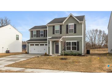 Two-story home featuring green siding, black shutters, a two-car garage and a well-manicured lawn at 3219 E Maygrove Dr, Danville, IN 46122