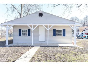 Charming home featuring blue shutters, a covered porch and updated neutral siding in a residential neighborhood at 4123 S Lynhurst Dr, Indianapolis, IN 46221