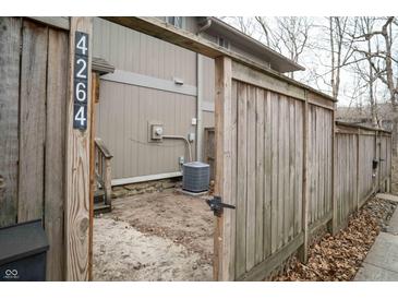Small side yard behind a wooden gate, shows the side of the home and an A/C unit at 4264 Foxglove Trce, Indianapolis, IN 46237