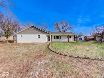 Charming one-story home with a white brick exterior, covered porch, and a well-manicured lawn at 6780 N Michigan Rd, Fairland, IN 46126