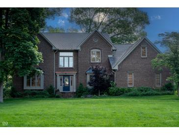 Charming two-story brick home featuring a well-manicured lawn and mature trees at 895 Baywood Ct, Columbus, IN 47201
