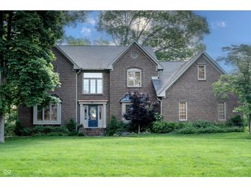 Charming two-story brick home with a well-manicured lawn and mature trees, showcasing classic architectural details at 895 Baywood Ct, Columbus, IN 47201