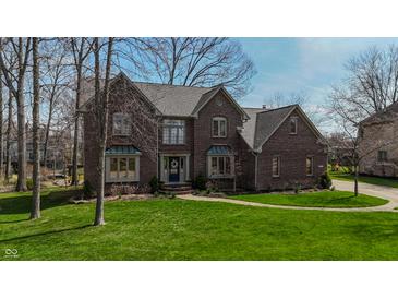 Charming brick two-story home featuring lush green lawn and mature trees at 895 Baywood Ct, Columbus, IN 47201