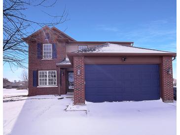 Charming two-story brick home with a blue garage door and well-maintained lawn at 1155 Dark Star Ct, Whiteland, IN 46184