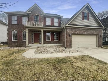 Traditional two-story brick home featuring red shutters, attached two car garage and manicured front lawn at 12036 Weathered Edge Dr, Fishers, IN 46037
