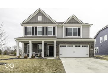 Charming two-story home featuring a brick facade, attached two-car garage and covered porch with seating area at 4078 Omaha Dr, Bargersville, IN 46106