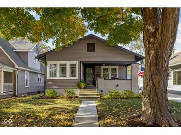 Charming home showcasing a landscaped front yard, inviting porch and traditional architectural design at 4818 Guilford Ave, Indianapolis, IN 46205