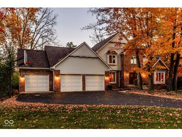 Charming home with a three car garage, brick accents and a well manicured yard, surrounded by beautiful fall foliage at 5015 Watersite Cir, Indianapolis, IN 46254