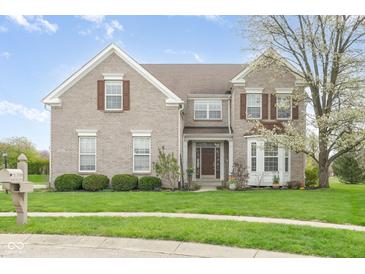 Charming two-story brick home featuring well-maintained landscaping and a beautiful, blossoming tree in the front yard at 5769 Marsh Glen Ct, Carmel, IN 46033