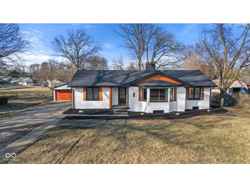 Charming exterior showcasing a brick home with a dark roof, wood accents, and a well-maintained front yard at 6470 Jackson St, Indianapolis, IN 46241