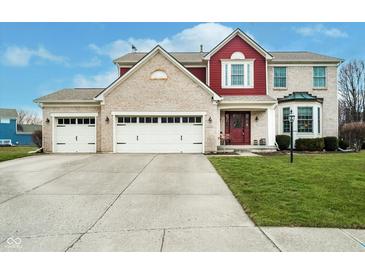 Charming brick and siding home featuring a three-car garage, well-manicured lawn, and inviting front entrance at 8238 Armadale Ct, Indianapolis, IN 46236