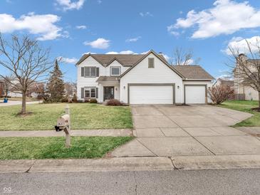 Traditional-style home featuring a three-car garage, lawn, and driveway at 10827 Putnam Pl, Carmel, IN 46032