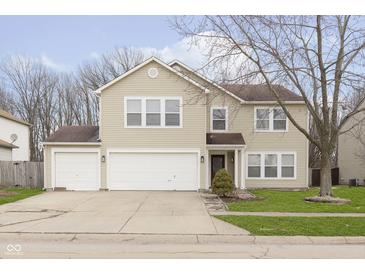 Charming two-story home with a three car garage and well-manicured lawn at 3113 Cassara Dr, Indianapolis, IN 46203