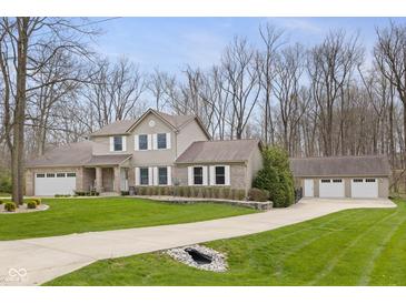 Traditional two-story home with a well-manicured lawn, attached garage, and detached garage in a treed area at 34 Gettysburg, Coatesville, IN 46121