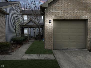Charming two-story townhouse with a brick-lined garage and well-manicured lawn at 3708 Magenta Ln # 3, Indianapolis, IN 46214