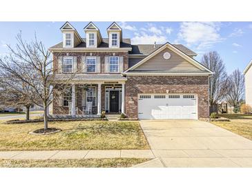 Charming two-story brick home featuring a front porch, well-manicured lawn and attached two car garage at 5524 Goodwin St, Indianapolis, IN 46234