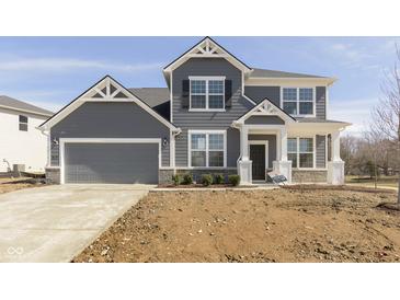 Charming two-story home with gray siding, stone accents, attached two car garage, and well-manicured front yard at 7181 Barrett Dr, Brownsburg, IN 46112