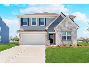 Charming two-story home featuring a manicured lawn, attached two-car garage, and a mix of vinyl siding and brick accents at 7658 Hillway Dr, Indianapolis, IN 46113