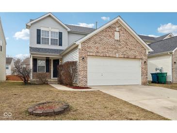 Charming two-story home with brick accents, a two-car garage, and a cozy front yard fire pit at 8074 Carina Dr, Indianapolis, IN 46268