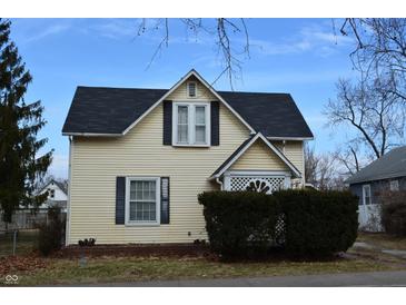 Charming two-story home with light yellow siding, black roof and shutters at 1228 E Perry St, Indianapolis, IN 46227