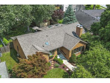 Aerial view of a brick home with a chimney, mature trees, and a well-manicured front yard at 14 Kessler Blvd W Dr, Indianapolis, IN 46208