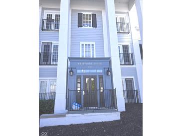 Classic building entrance featuring stately white pillars and dark door with address above, 
