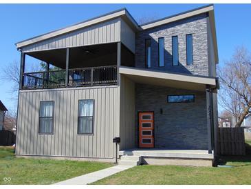 Two-story home featuring modern design with an inviting orange door and covered porch at 2528 Carrollton Ave, Indianapolis, IN 46205