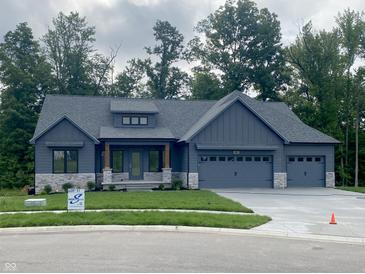 Charming single-story home featuring a three-car garage, stone accents, and a well-manicured lawn at 3604 Maple Ridge Dr, Columbus, IN 47201