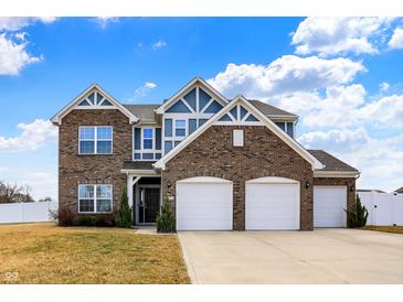 Beautiful two-story brick home with a three-car garage, blue accents, and manicured landscaping at 61 Larimar Way, Whiteland, IN 46184